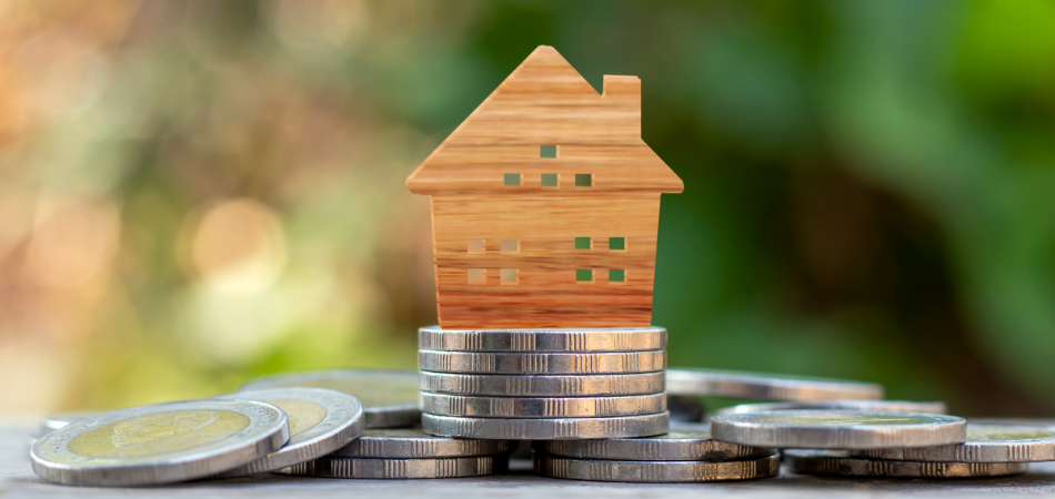 Small wood cutout house on coins