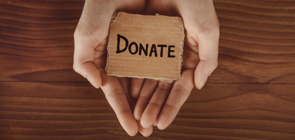 Hands holding a cutout cardboard that says DONATE